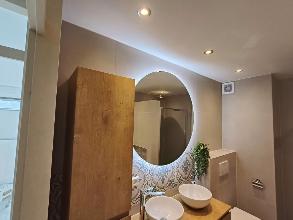 Moderne badkamer met houten meubels, dubbele wastafel, inloopdouche en ligbad in Alphen aan den Rijn.