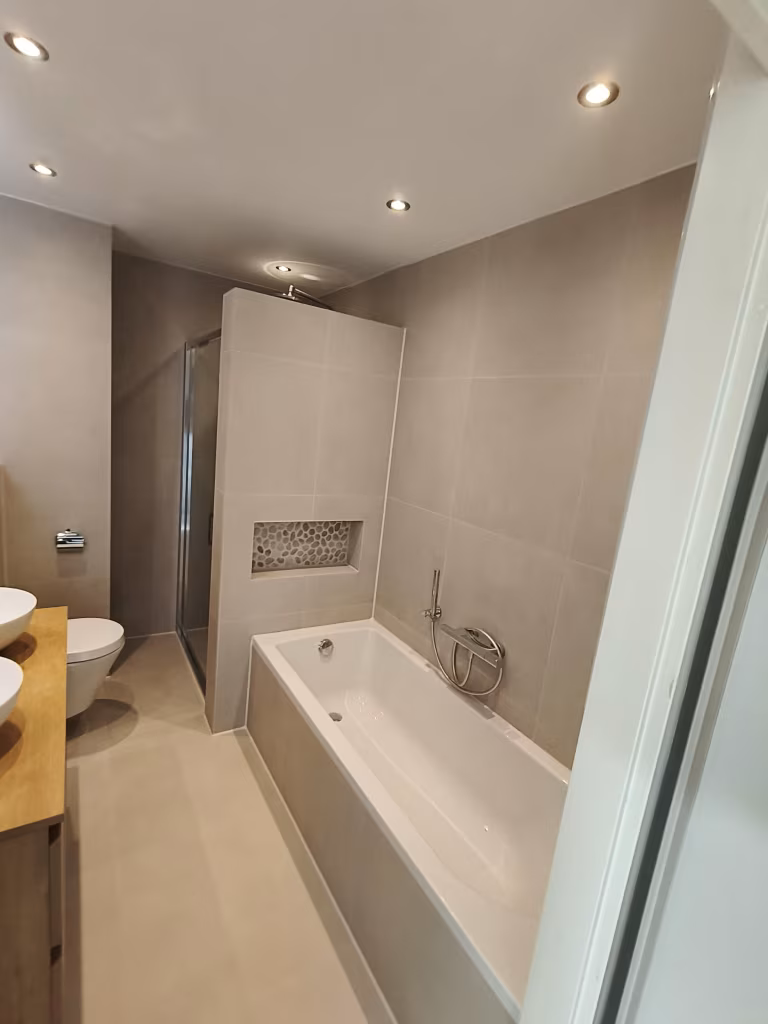 Moderne badkamer met houten meubels, dubbele wastafel, inloopdouche en ligbad in Alphen aan den Rijn.
