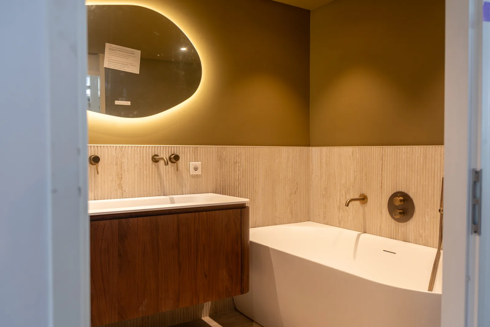 Complete badkamerrenovatie in Alphen aan den Rijn met vrijstaand bad, notenhouten wastafelmeubel en gouden accenten