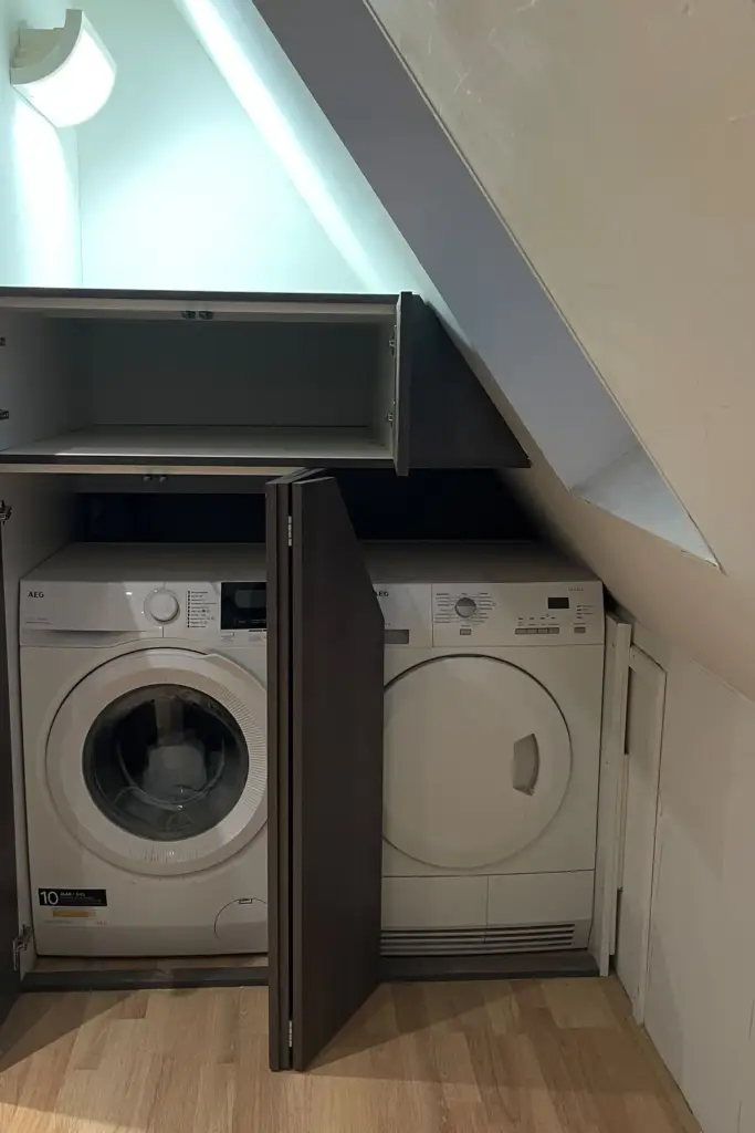 wasmachinekast-schuine-kap-alphen-aan-den-rijn-gesloten-voor` | Wasmachinekast op maat, onderdeel van dezelfde kastenwand, met wasmachine en droger weggewerkt