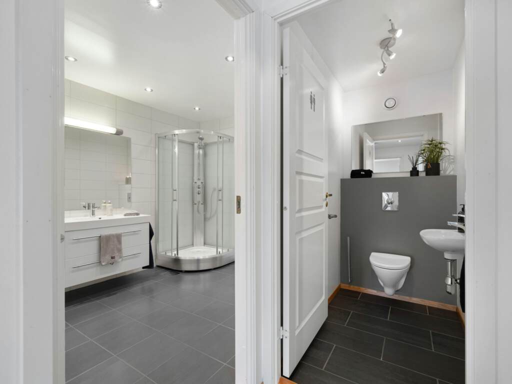 Witte badkamer met inloopdouche naast een wastafel